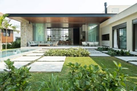 Materiais naturais e vidro garantem contato com a natureza nesta casa